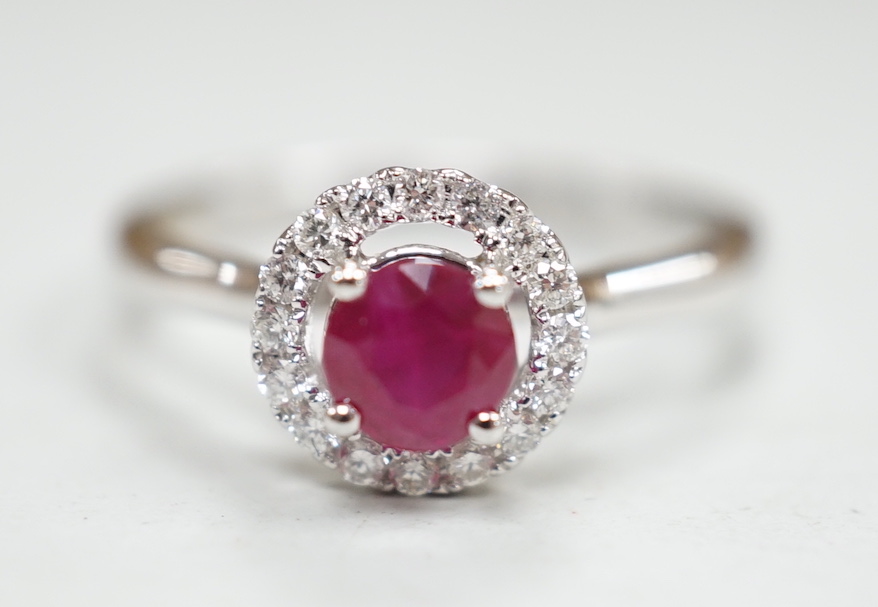 A modern 18ct white gold, ruby and diamond set circular cluster ring, size M, gross weight 3.1 grams.
